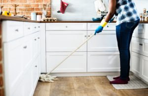 person mopping the floor of a kitchen