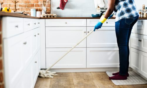 person mopping the floor of a kitchen