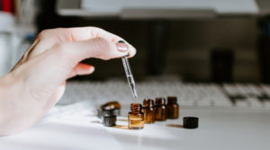 hand putting essential oil into dropper bottle