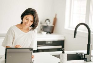 woman at her kitchen island with ipad